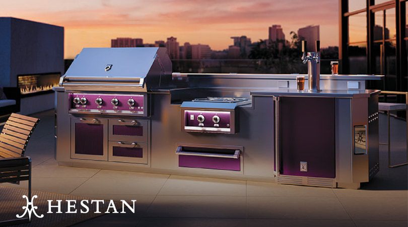 Hestan Outdoor luxury kitchen with stainless steel built-in grill and premium cabinetry at sunset